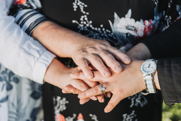 Gros plan d'une famille de femmes religieuses mettant leurs mains ensemble et priant Portrait de famille