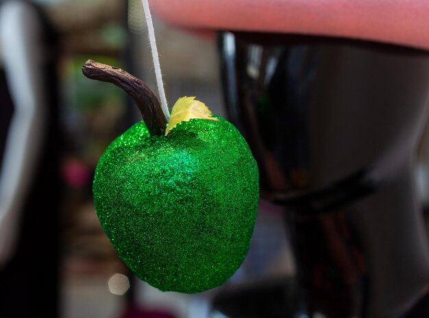 Gros plan sur une fausse pomme verte recouverte de paillettes