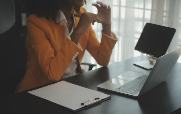 Gros plan femme d'affaires à l'aide d'une calculatrice et d'un ordinateur portable pour faire des finances mathématiques sur un bureau en bois statistiques de comptabilité fiscale et concept de recherche analytique