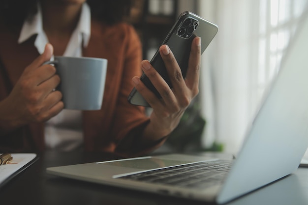 Gros plan femme d'affaires à l'aide d'une calculatrice et d'un ordinateur portable pour faire des finances mathématiques sur un bureau en bois statistiques de comptabilité fiscale et concept de recherche analytique