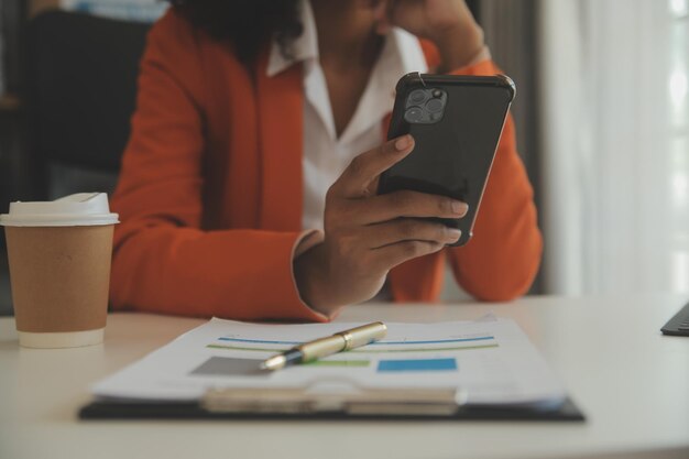 Gros plan femme d'affaires à l'aide d'une calculatrice et d'un ordinateur portable pour faire des finances mathématiques sur un bureau en bois statistiques de comptabilité fiscale et concept de recherche analytique