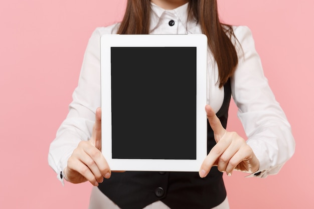 Gros plan d'une femme d'affaires souriante tenant un ordinateur tablette avec un écran vide vierge isolé sur fond rose pastel. Dame patronne. Concept de richesse de carrière de réalisation. Copiez l'espace pour la publicité.