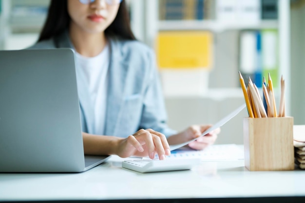 Photo gros plan sur une femme d'affaires travaillant au bureau à l'aide d'un ordinateur portable