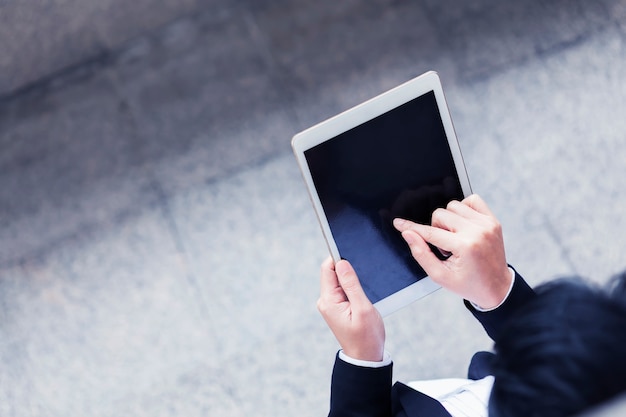 Photo gros plan de femme d'affaires en utilisant internet sur tablette en plein air dans la ville