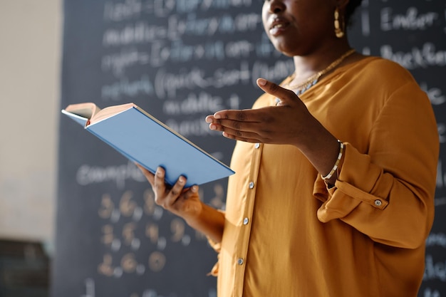 Gros plan d'une femme afro-américaine lisant un livre pendant la leçon à l'école