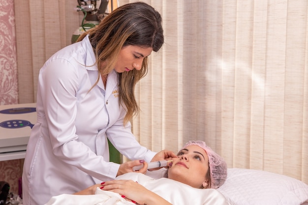 Gros plan d'une femme appliquant de l'ozone sur son visage pour un traitement cosmétique.