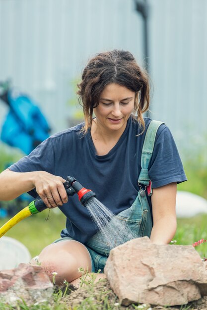 Gros plan de femme arrosant les plantes dans le jardin