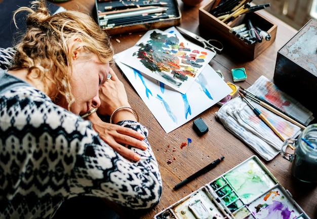 Photo gros plan d'une femme artiste faisant une sieste sur une table de travail