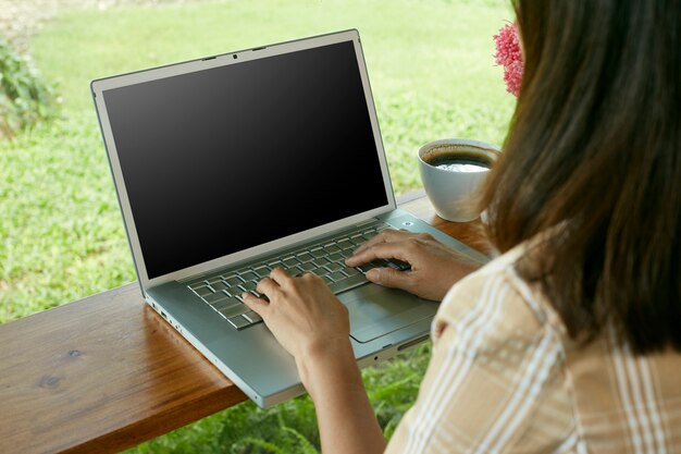 Gros plan de femme assise à la maison à l'aide d'un ordinateur portable