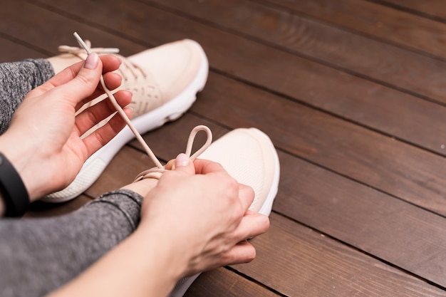 Gros plan, femme, attacher, chaussure, lacets, gymnase