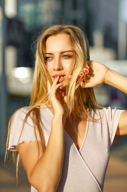 Gros plan d'une femme blonde glamour avec une peau parfaite et un maquillage nu posant sur l'avenue