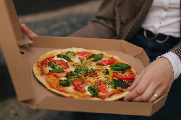 Gros plan de femme boîte à pizza ouverte à l'extérieur