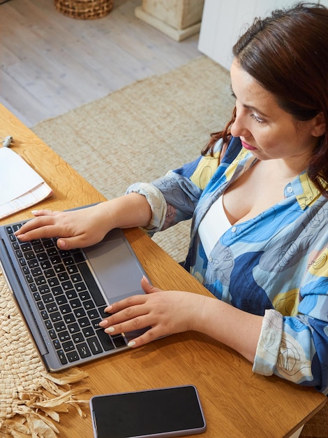 Gros plan femme brune utilisant un ordinateur portable travail à distance à la maison formation de consultation en ligne