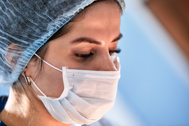 Gros plan sur une femme chirurgienne dans une salle d'opération, un médecin avec une expression tendue sur son visage, dans une salle d'opération.