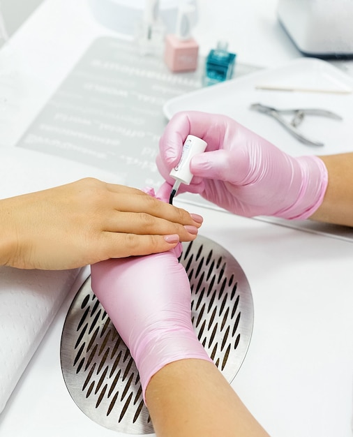 Gros plan d'une femme dans un salon de manucure recevant une manucure par une esthéticienne avec une lime à ongles