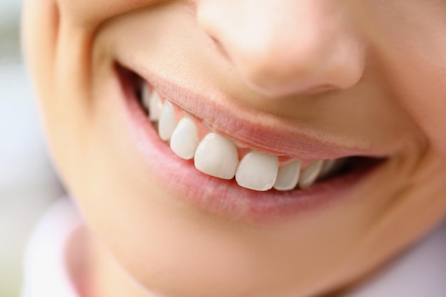 Gros plan d'une femme avec des dents blanches parfaites et saines macro shot of laughing female smiling on