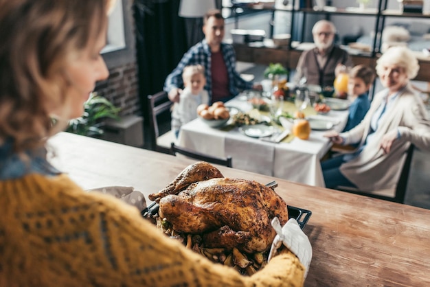 gros plan d'une femme avec une dinde de thanksgiving pour un dîner de vacances en famille