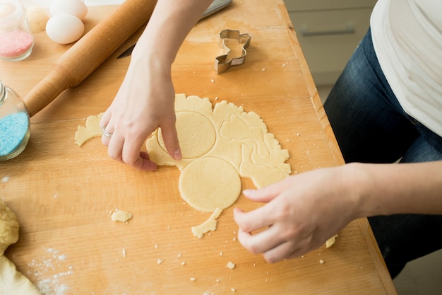 Gros plan d'une femme faisant des biscuits coupant la pâte avec du moule