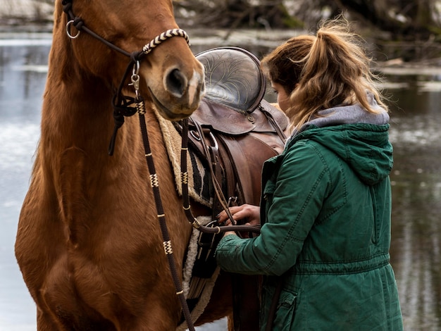 Gros plan, femme, fixation, selle, cheval