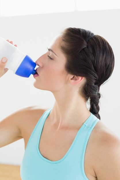 Gros plan d&#39;une femme en forme d&#39;eau potable au gymnase