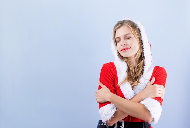 Gros plan d'une femme heureuse caucasienne portant des vêtements de père noël en riant