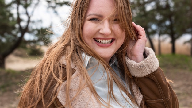 Gros plan femme heureuse à l'extérieur