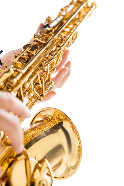 Gros plan femme jouant du saxophone isolé sur fond de studio blanc. Musicien inspiré, détails de l'occupation artistique, instrument classique mondial pour le jazz et le blues. Concept de passe-temps, créativité.