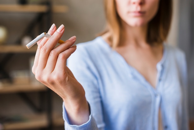 Photo gros plan, de, femme, main, tenue, cassé cigarette