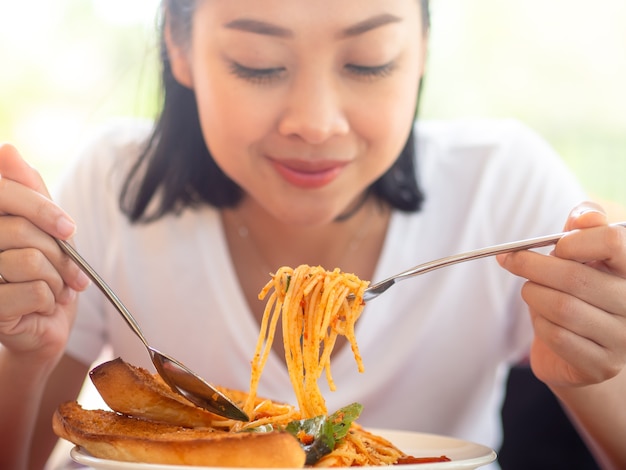 Gros plan de femme mange des spaghettis.