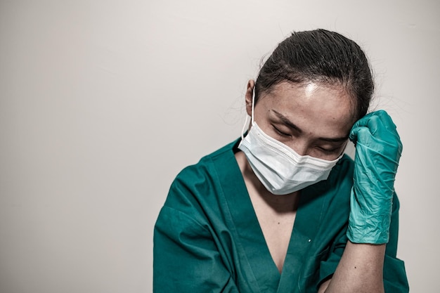 Gros plan femme médecin asiatique porter un masque pour protéger le virus covid19 Elle est triste et stressée par le travail beaucoup