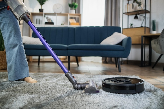 Gros plan sur une femme nettoyant un tapis avec des aspirateurs