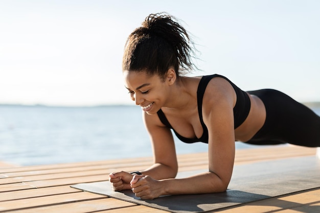 Photo gros plan d'une femme noire motivée qui planche sur la plage