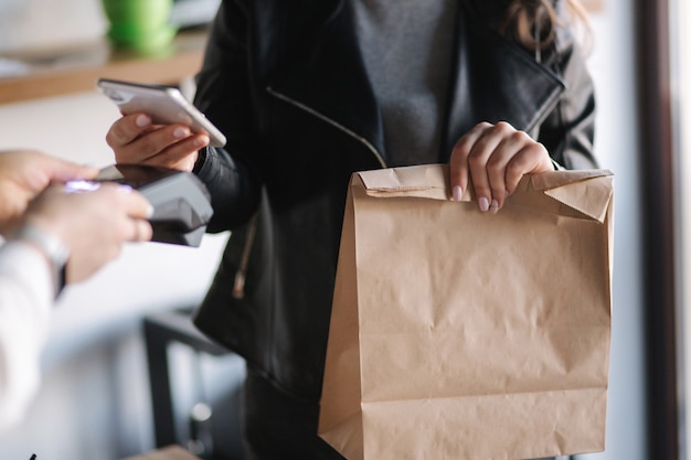 Gros plan de femme payant avec smartphone