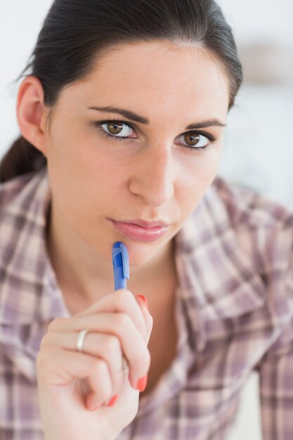 Gros plan d&#39;une femme en pensant en regardant la caméra