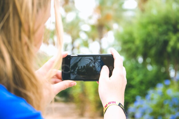 Photo un gros plan d'une femme photographiant à travers un smartphone