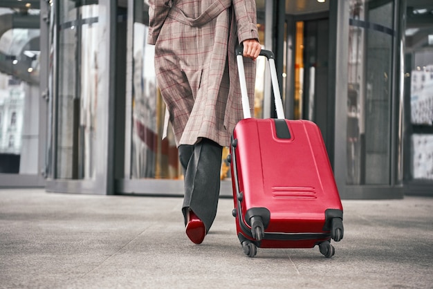 Gros Plan Sur Une Femme Portant Une Valise Au Terminal De L'aéroport Et Se Dépêchant De S'enregistrer En Vacances Ou En Voyage D'affaires.