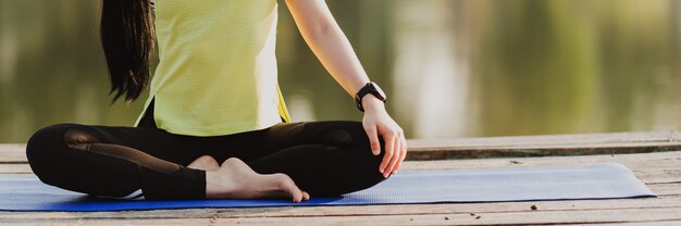 Gros plan femme pratiquant le yoga faisant du yoga dans le parc du matin