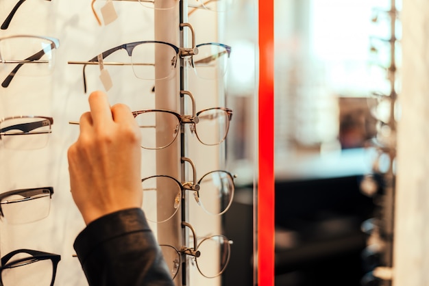 Gros plan d&#39;une femme prenant des lunettes d&#39;étagère.