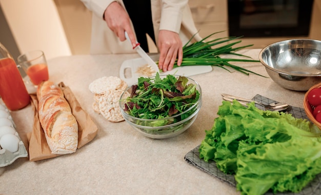 Gros plan d'une femme préparant une salade végétalienne de légumes dans la cuisine Concept d'alimentation et de régime alimentaire sain Cuisiner à la maison
