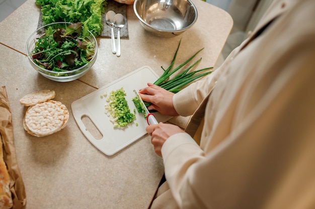 Gros Plan D'une Femme Préparant Une Salade Végétalienne De Légumes Dans La Cuisine Concept D'alimentation Et De Régime Alimentaire Sain Cuisiner à La Maison