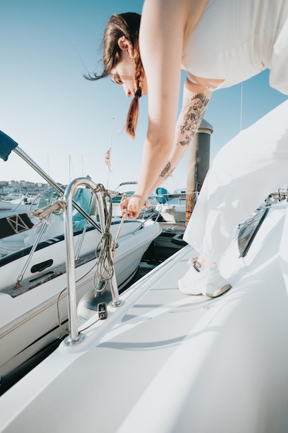 Gros plan femme préparant avec ses mains un noeud et une proue du bateau Fabrication d'un noeud nautique sur son yacht se préparant à naviguer tout en voyageant en mer méditerranée Voyages de luxe