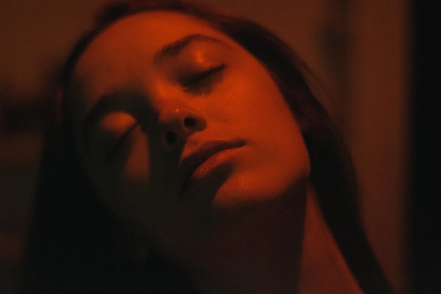 Un gros plan d'une femme qui dort dans la chambre noire.