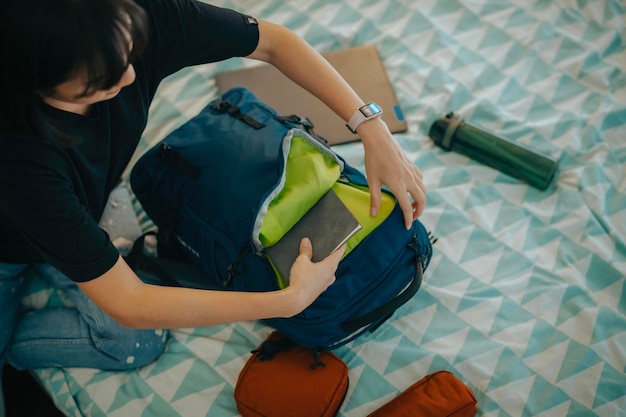 gros plan, une femme qui faisait ses bagages a mis le livre dans son sac sous l'angle du haut