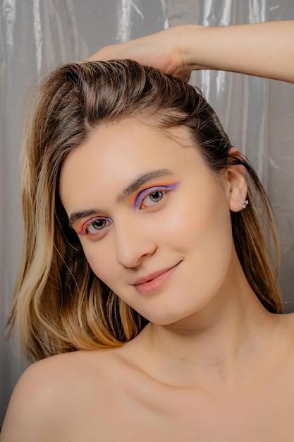 Gros plan sur une femme de race blanche avec un eye-liner orange et violet