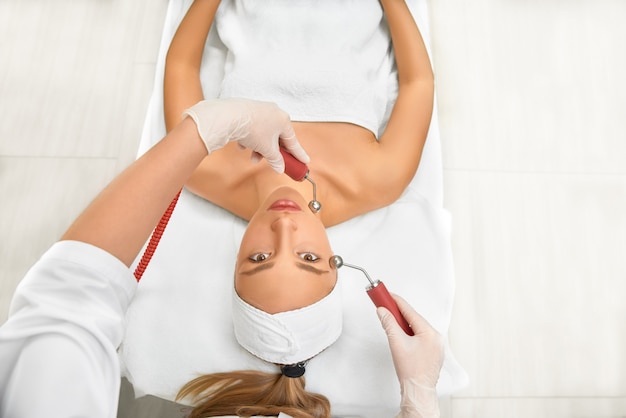 Gros plan d'une femme recevant un massage facial électrique