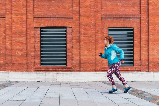 Un gros plan d'une femme rousse sportive faisant des exercices en plein air