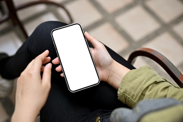 Gros plan Une femme se détend dans le jardin en utilisant le défilement d'un smartphone sur les réseaux sociaux