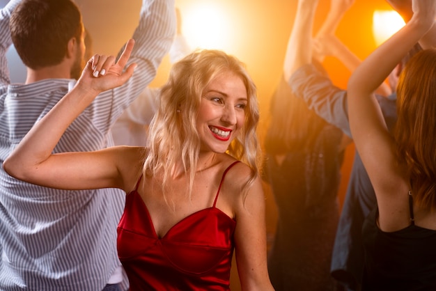 Gros plan femme souriante dansant au club