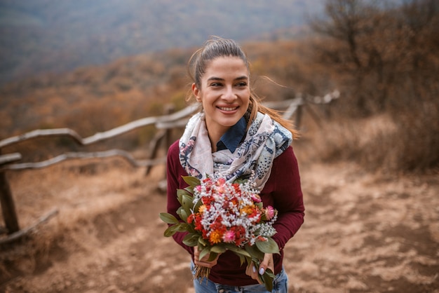 Gros plan de femme tenant le bouquet en se tenant debout à l'extérieur.