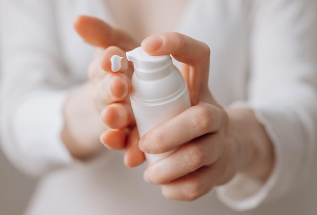 Gros plan femme tenant de la crème pour les mains Femme appliquant de la crème pour les mains